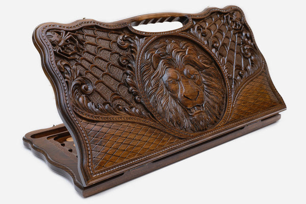 Carved beechwood backgammon board with a lion medallion and spider webs, with a carry handle, propped open