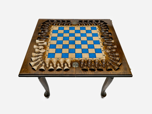 Standing chess table with a blue epoxy board and turned wooden pieces arranged around the border, on cabriole legs