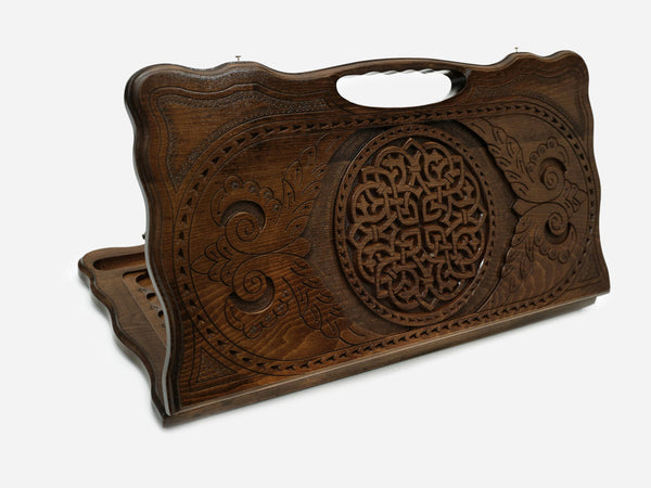 Carved beechwood backgammon board with an interlaced knotwork rosette and a carry handle, propped open