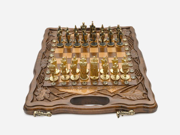 Walnut chess and backgammon set open to the chessboard with figural metal pieces