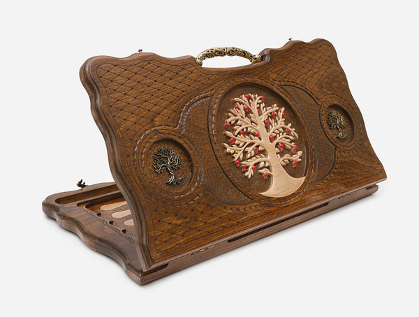 Carved beechwood backgammon board with a bronze tree of life medallion and ornate bronze carry handle, shown propped open
