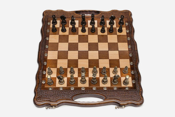 Folding walnut chess board with carved corners and ornate bronze figural pieces - dark and gold armies in starting position