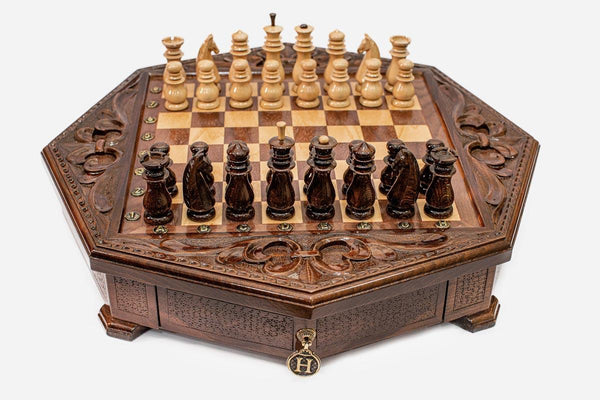 Octagonal wooden chess set with carved fleur-de-lis border and Staunton pieces set up on the inlaid board