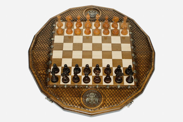 Twelve-sided carved chess board with an inlaid Russian coat-of-arms medallion and turned wooden pieces set up for play
