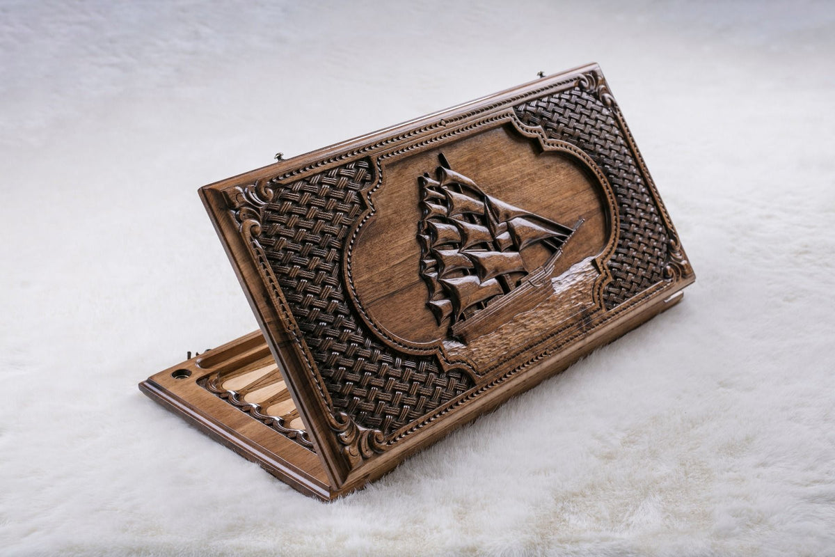 Hand-carved walnut backgammon set with a tall ship design across the cover