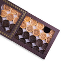 Close-up of wooden backgammon pieces with the Coat of Arms of Russia engraved.
Set