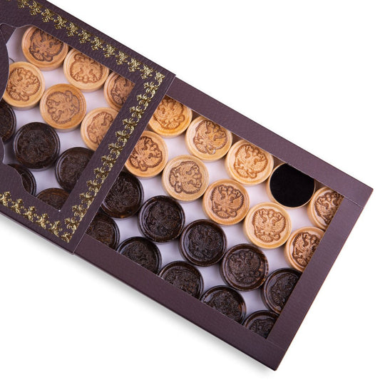 Close-up of wooden backgammon pieces with the Coat of Arms of Russia engraved.
Set