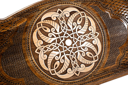 Close-up of the hand-carved Armenian braid ornament in light wood on the lattice ground of the backgammon set cover