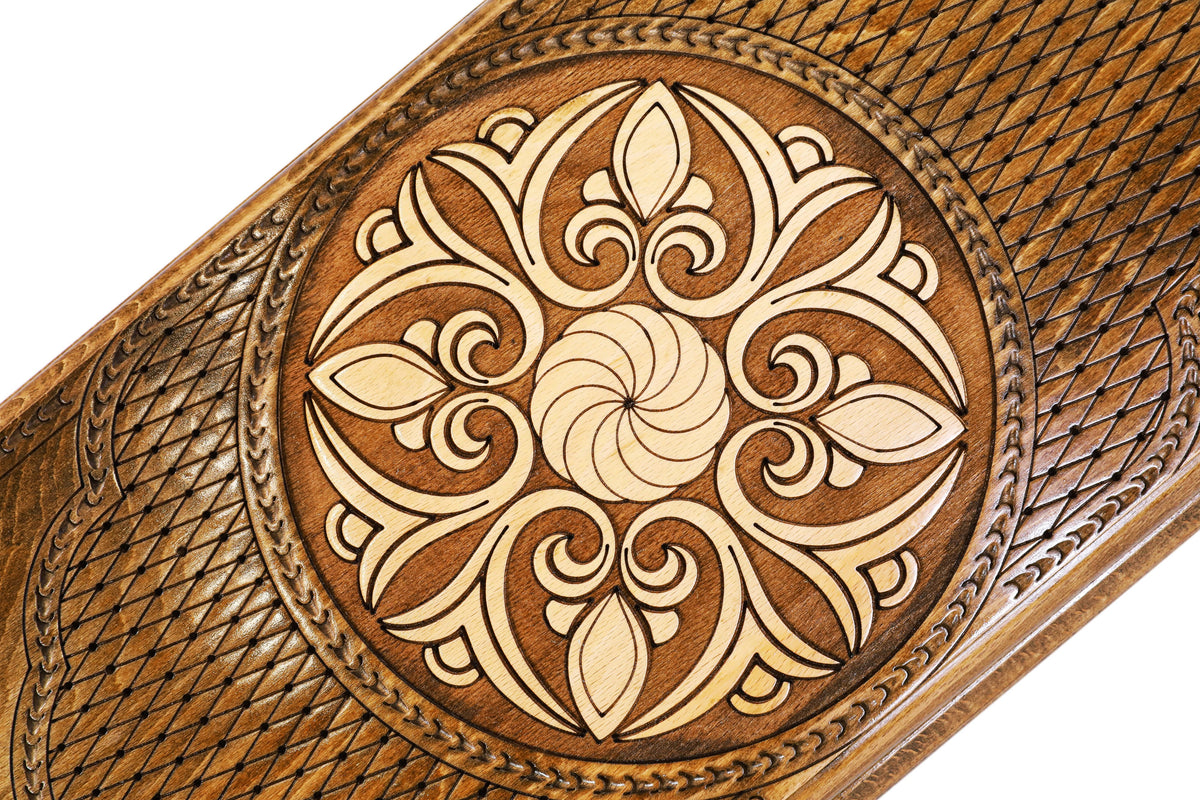 Close-up of the four-fold leaf ornament and eternity whirl in pale wood on the stippled round panel