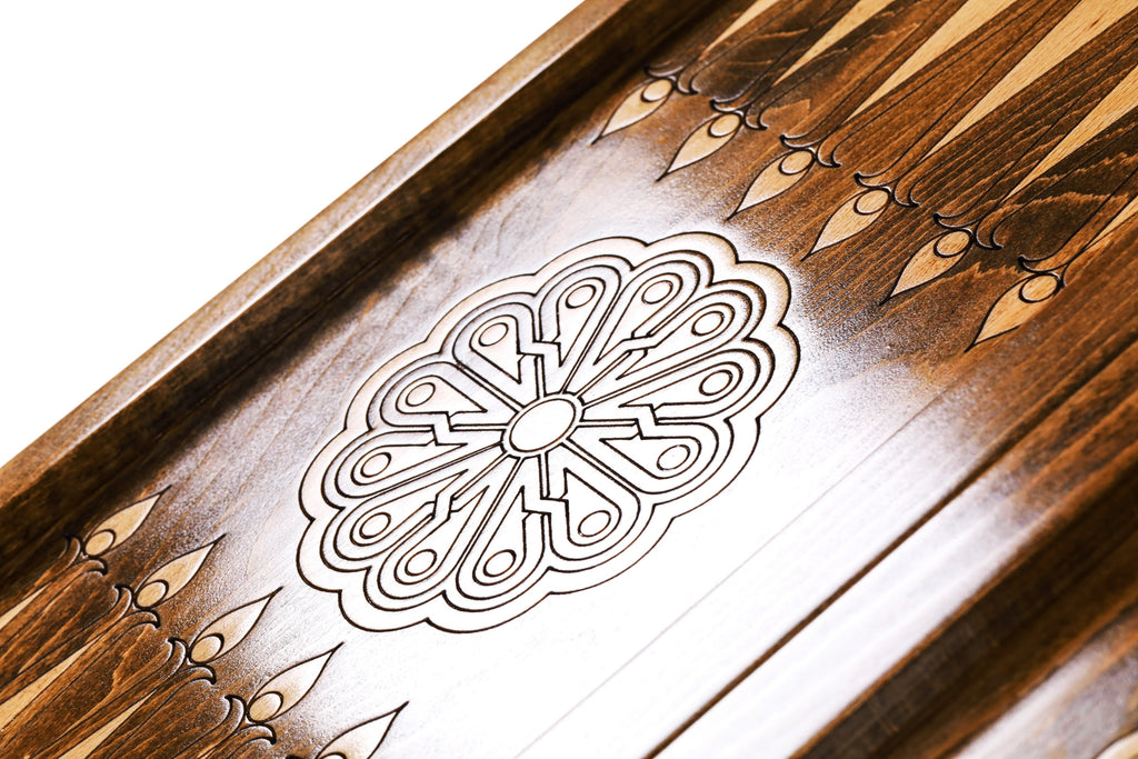 Eight-petal wheel ornament cut into the dark field of the open backgammon board