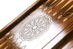 Eight-petal wheel ornament cut into the dark field of the open backgammon board