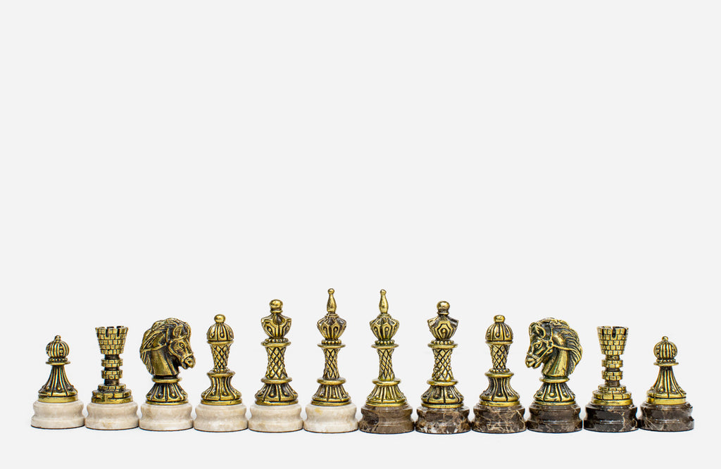 Row of the two-tone bronze chess pieces on marble bases, showing kings, queens, bishops and horse-head knights