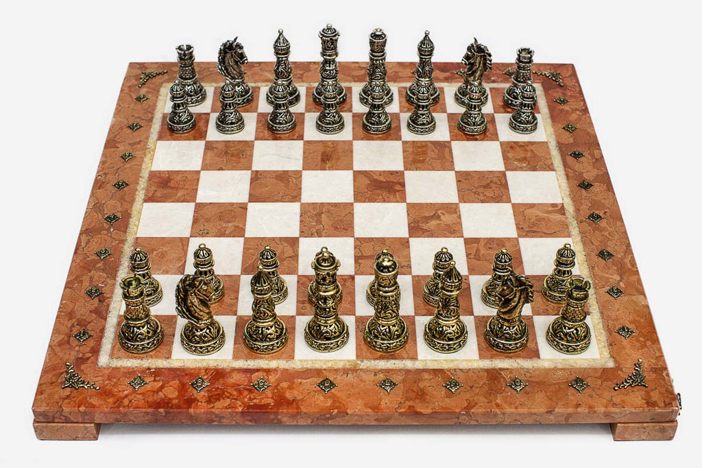 Coral and cream marble chess set with hand-cast bronze pieces arranged for play and brass coordinate medallions