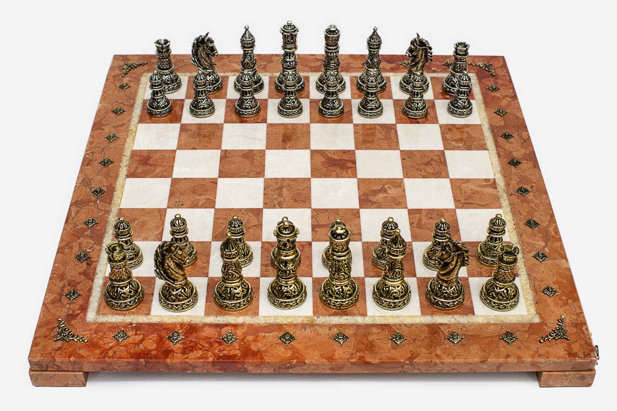 Coral and cream marble chess set with hand-cast bronze pieces arranged for play and brass coordinate medallions