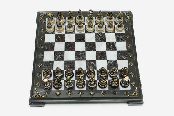 Burgundy and white marble chess set with hand-cast bronze pieces arranged for play and brass coordinate medallions