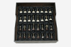 Bronze chess pieces with marble bases arranged in the black satin-lined wooden box
