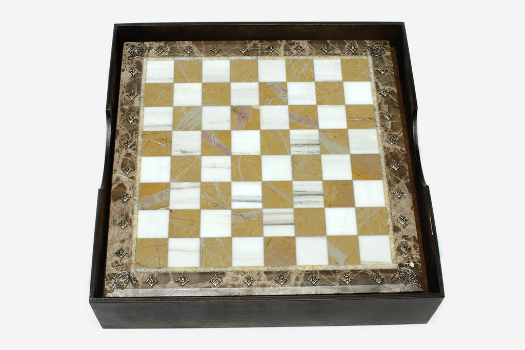 Golden and white marble chess board with hand-cast bronze pieces