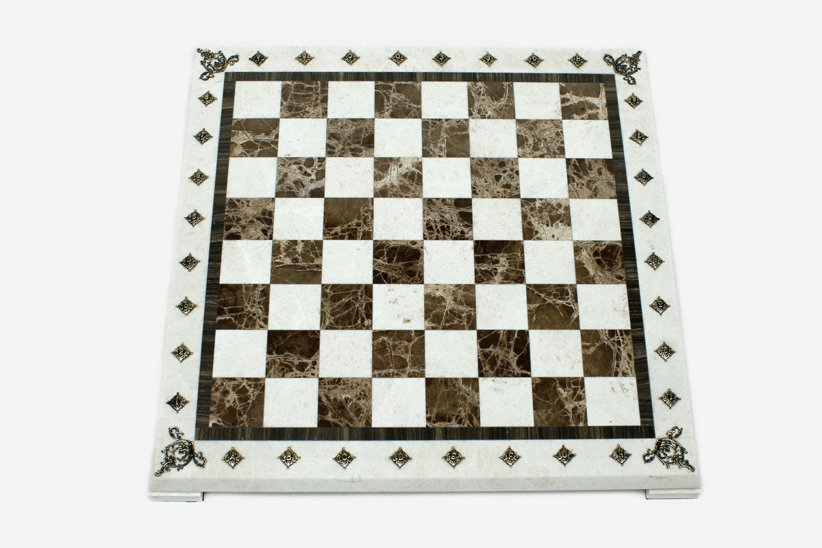 Top-down view of the empty cream and brown marble chess board with brass coordinate medallions