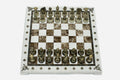 Cream and brown marble chess set with hand-cast bronze pieces arranged for play and brass coordinate medallions