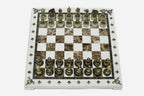 Cream and brown marble chess set with hand-cast bronze pieces arranged for play and brass coordinate medallions
