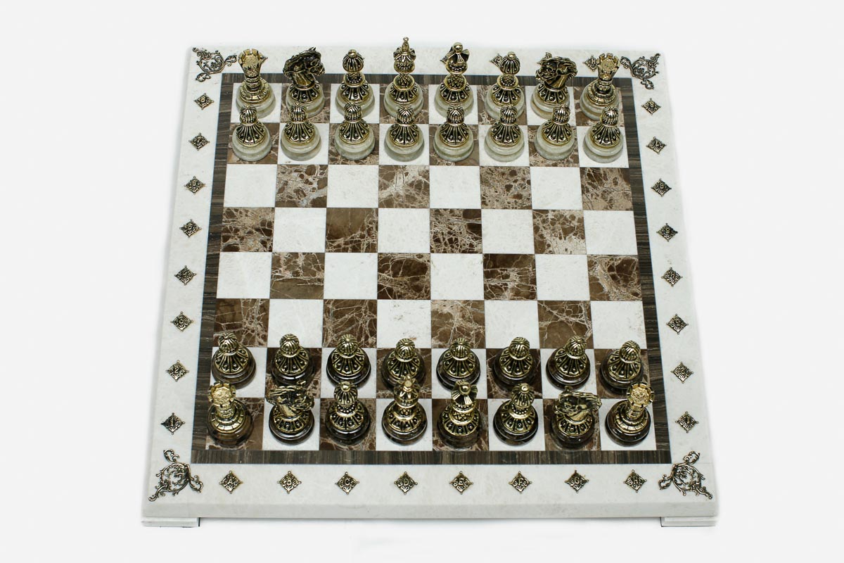 Cream and brown marble chess set with hand-cast bronze pieces arranged for play and brass coordinate medallions