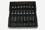 The full set of bronze chess pieces arranged in the black satin-lined wooden storage box