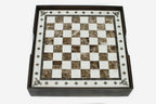 Top-down view of the cream-bordered brown marble chess board resting in its wooden case