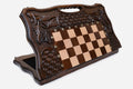 Large carved folding chess board standing open, showing the chessboard, basket-weave and foliate carving and carry-handle cutout