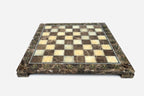 Front view of the brown marble chess board framed by brass letter and number medallions