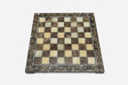 Top-down view of the empty brown and cream marble chess board with brass coordinate medallions