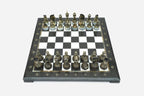 Elevated angle of the black marble chess board with bronze pieces and brass coordinate medallions