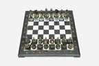 Black and white marble chess set viewed from the front with bronze pieces ready to play