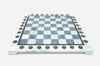 Front view of the grey and white marble chess board framed by brass coordinate medallions
