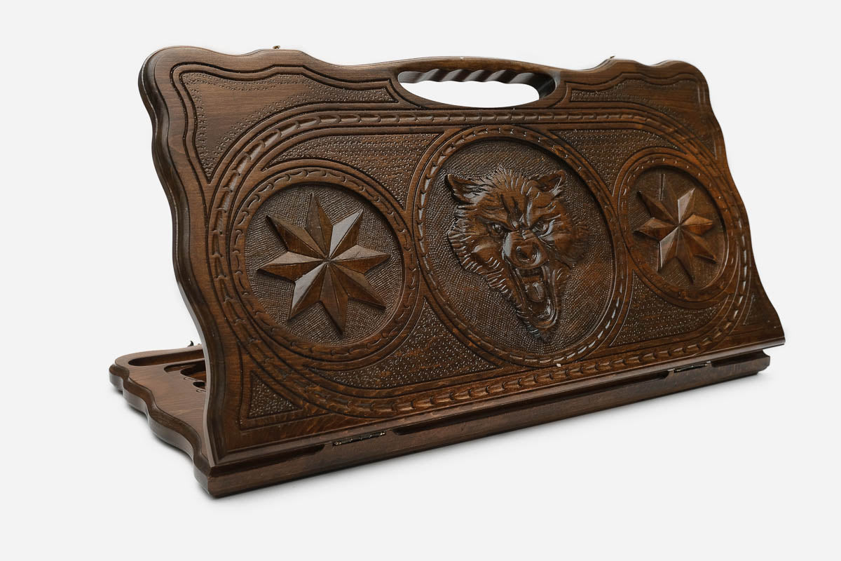 Carved beechwood backgammon board with a wolf and star medallions, with a carry handle, propped open