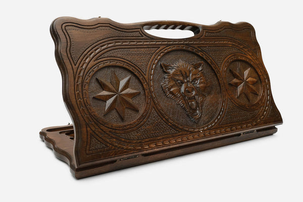 Carved beechwood backgammon board with a wolf and star medallions, with a carry handle, propped open