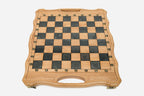 Close-up of the ornate bronze chess pieces on cream and walnut bases
