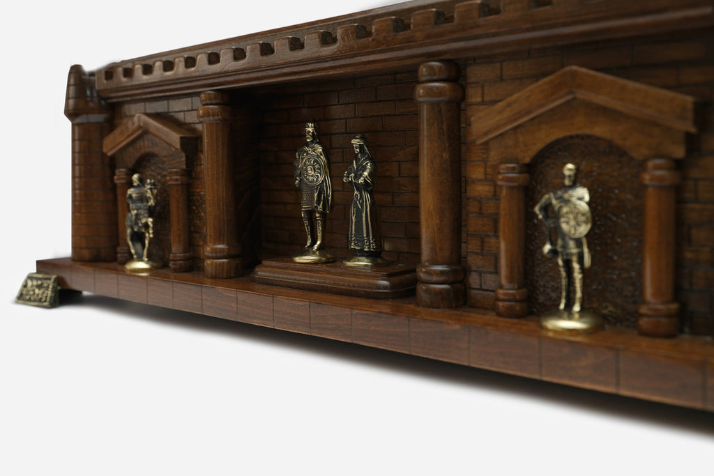 Close-up of the bronze king, queen and knight figures on the Chess Castle shelf