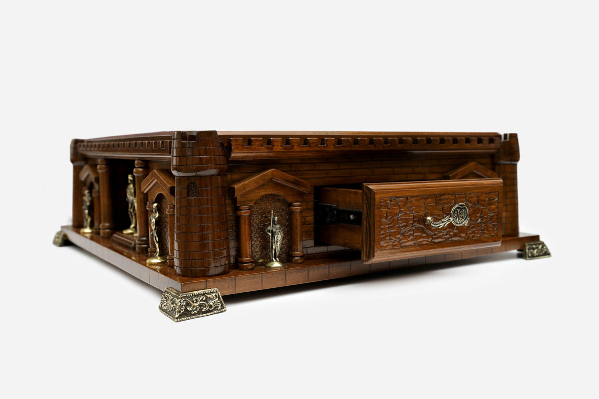 Handle Chess Castle side view with the drawer open beside the bronze knight statues