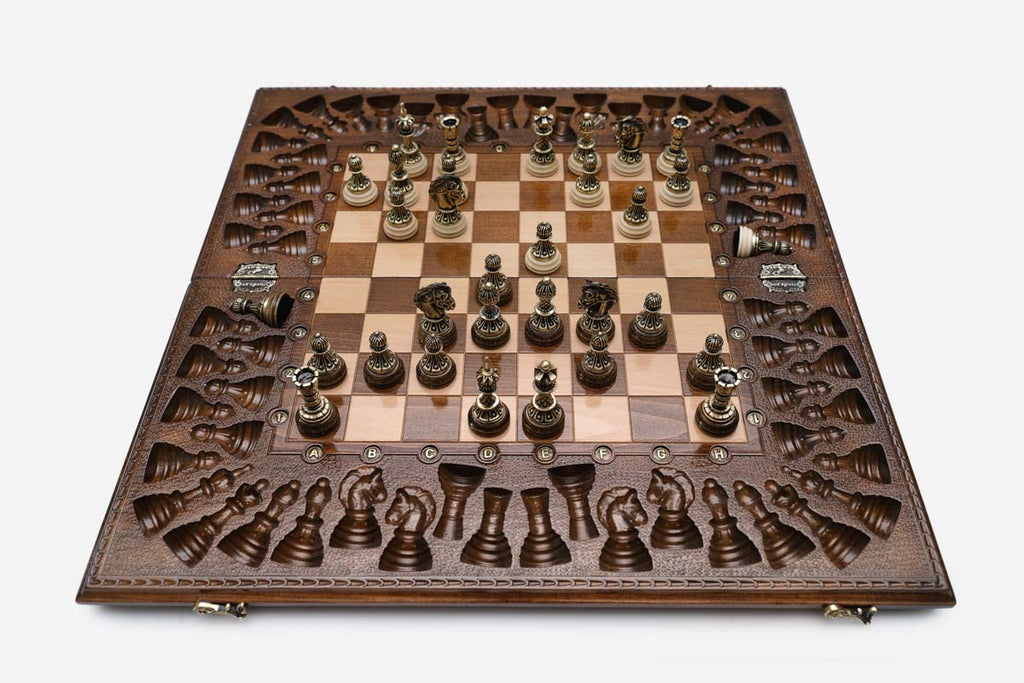 Close-up of the ornate bronze chess pieces with sculpted crowns and cream bases