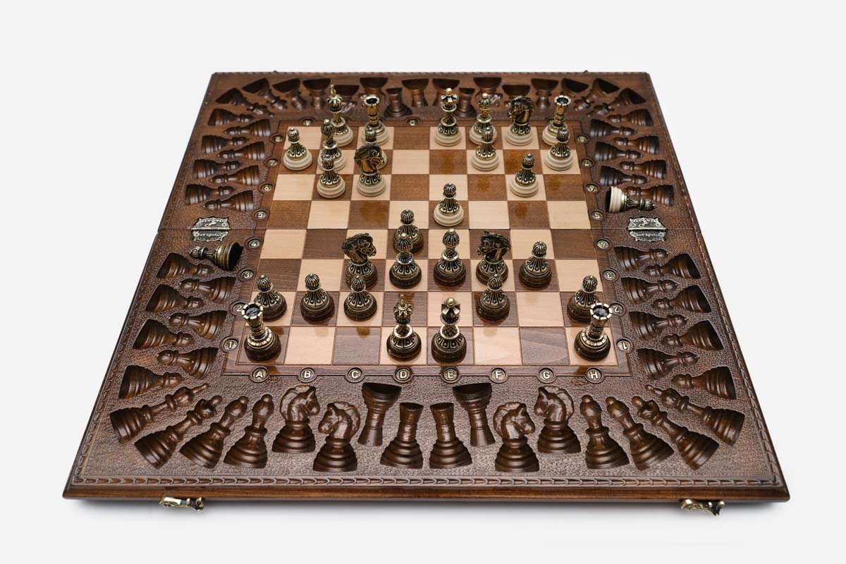 Close-up of the ornate bronze chess pieces with sculpted crowns and cream bases