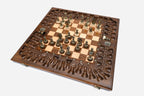 Overhead view of the full bronze-and-cream chess army on the inlaid board