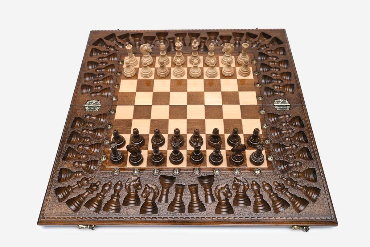 Angled view of the grand carved chess set with its bronze figural pieces