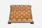 Angled view of the orange epoxy chess set with its bronze figural pieces