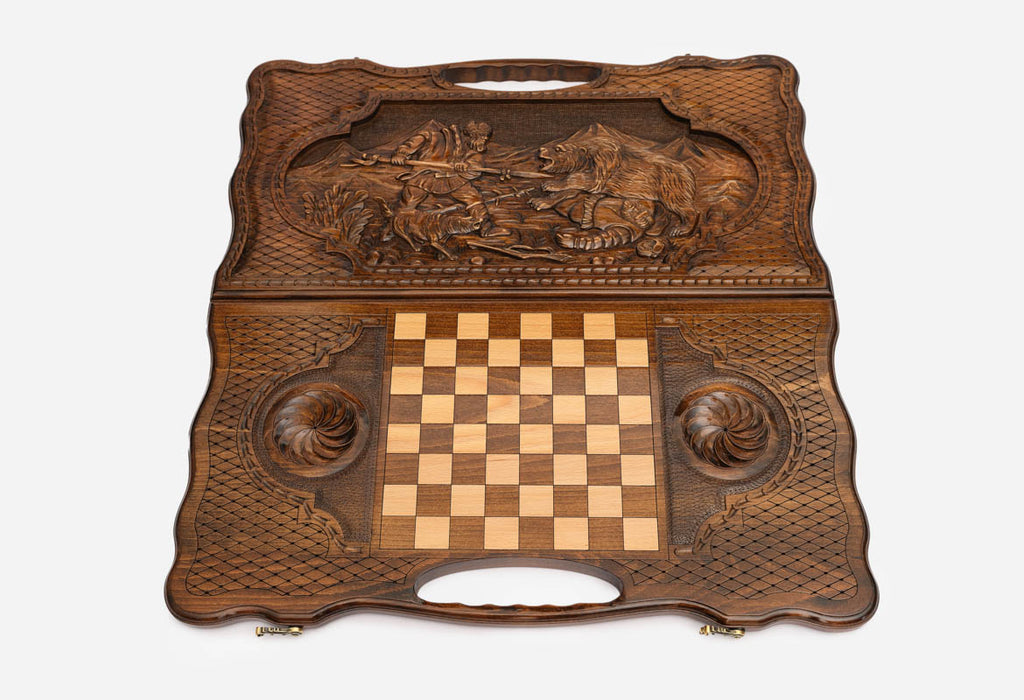 Angled view of the hunter and bear carved backgammon board