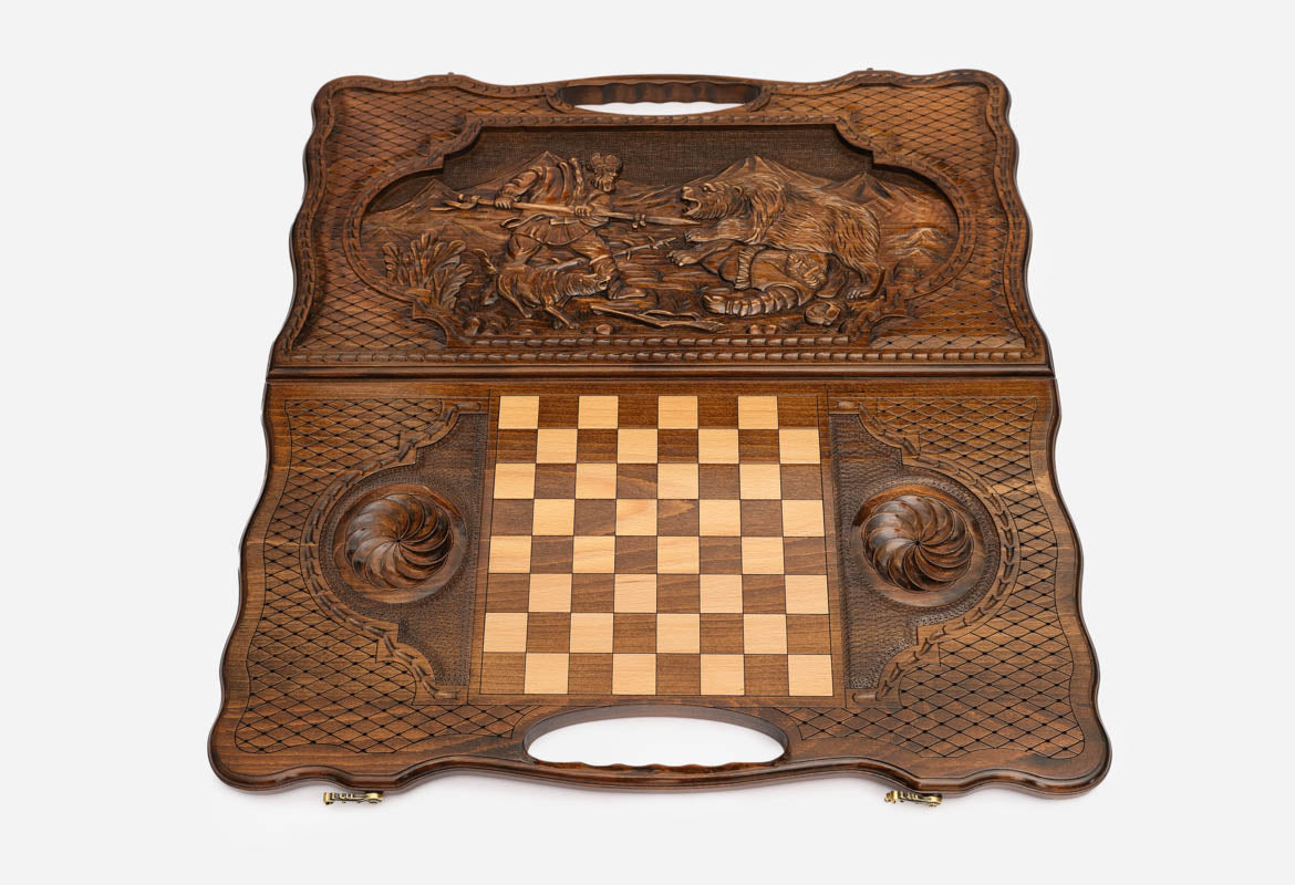 Angled view of the hunter and bear carved backgammon board