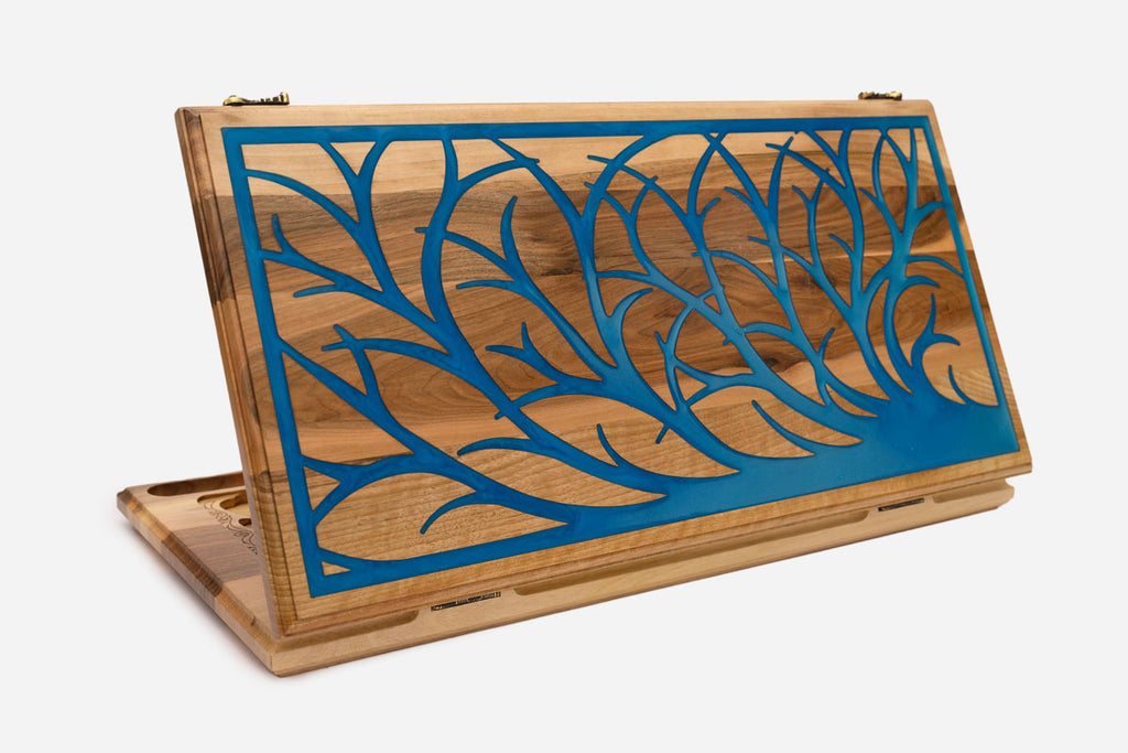 Folding walnut backgammon board carved with a tree of life filled with blue epoxy, propped open