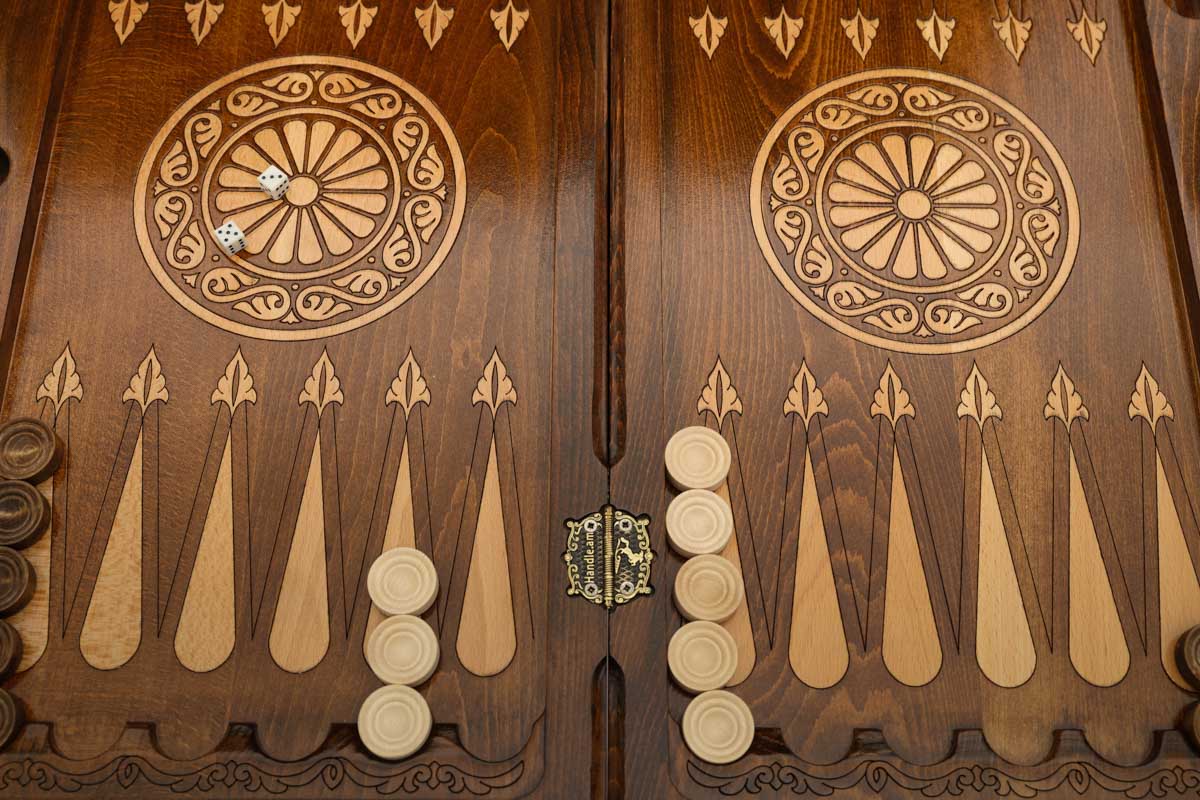Close-up of the backgammon checkers, dice and cup on the Handle Eagle table