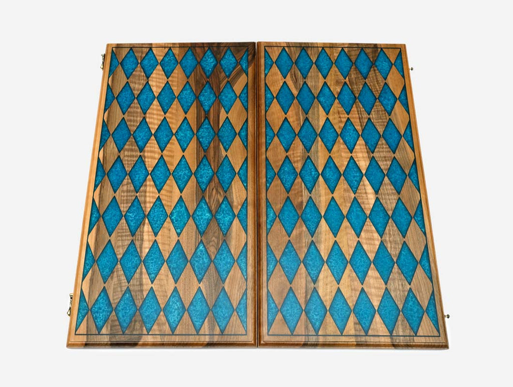The backgammon board opened to reveal blue playing points and carved rosettes