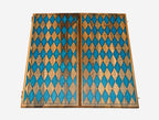 The backgammon board opened to reveal blue playing points and carved rosettes