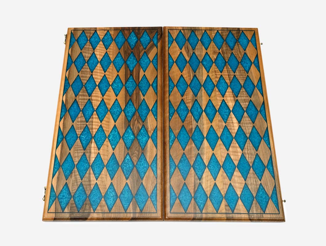 The backgammon board opened to reveal blue playing points and carved rosettes